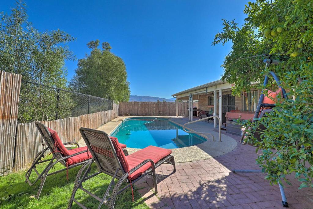 een tuin met 2 stoelen en een zwembad bij Pet-Friendly Tucson Home with Heated Pool and Hot Tub in Tucson