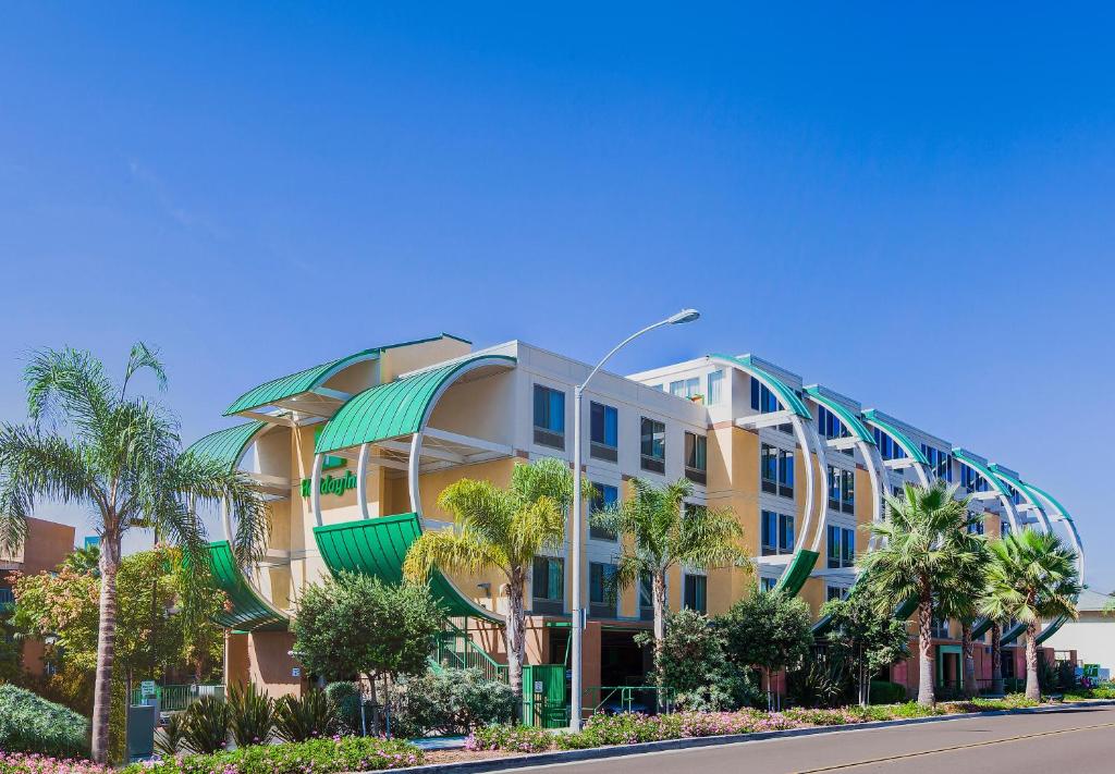 a building with palm trees in front of a street at Holiday Inn Oceanside Marina Camp Pendleton, an IHG Hotel in Oceanside