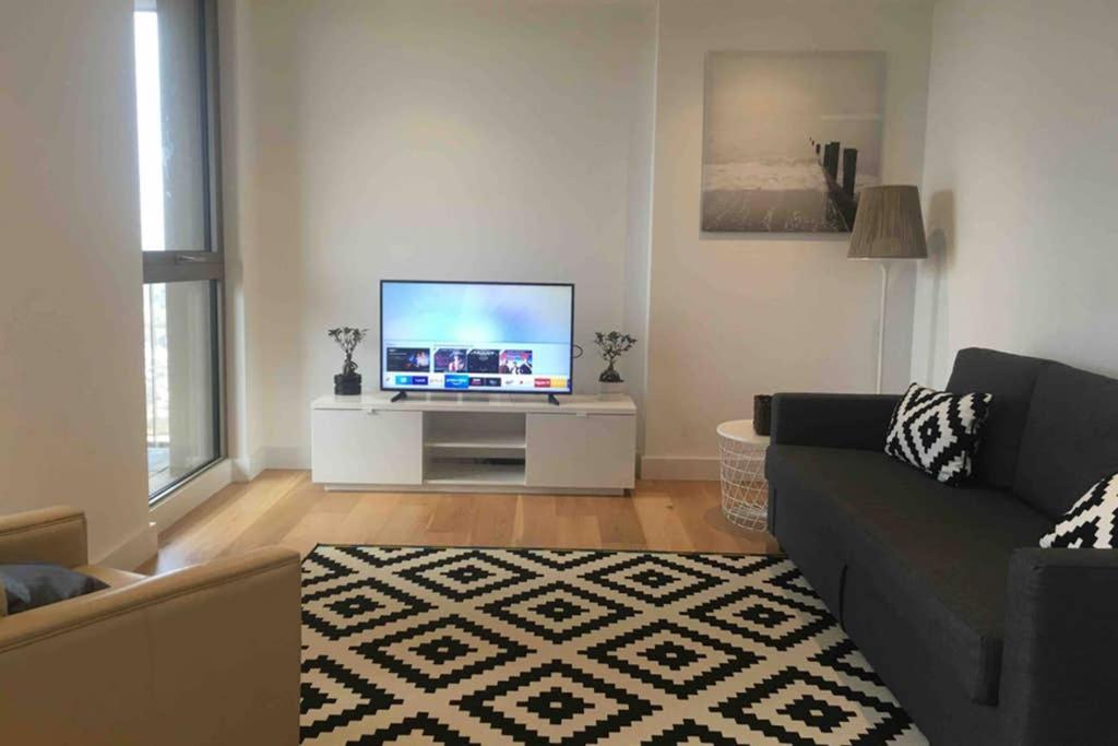 a living room with a couch and a flat screen tv at LUXURY SERVICED APARTMENTS***** in Croydon