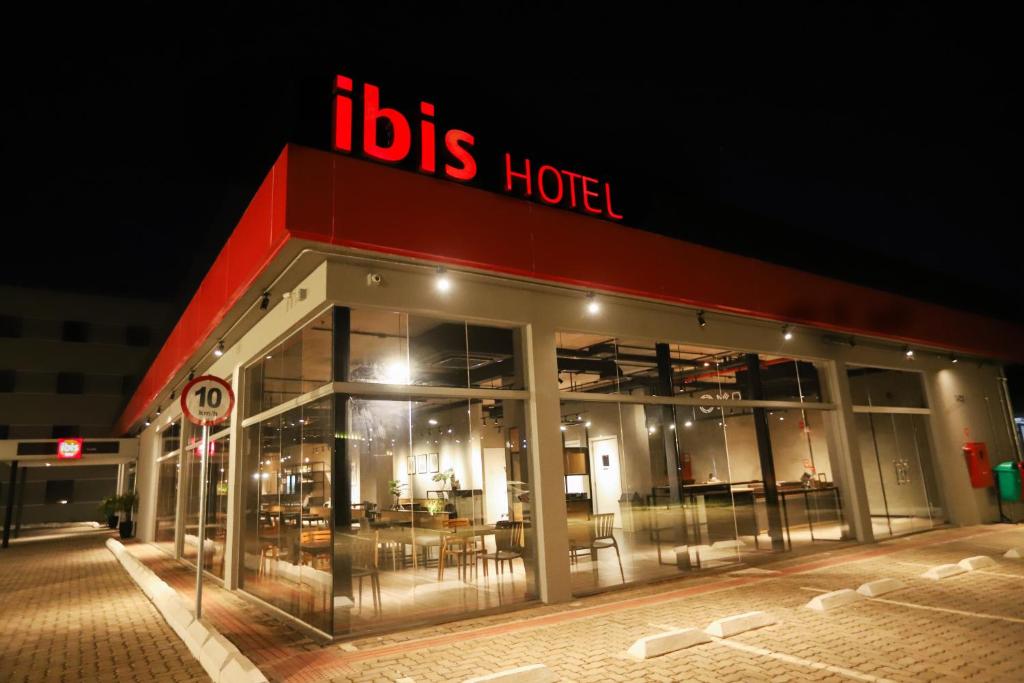 un bâtiment avec un grand panneau sur son côté dans l'établissement ibis Cuiaba Shopping, à Cuiabá