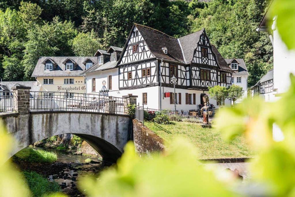 a bridge over a river in front of a building at Landgasthof zur Burg Grenzau in Höhr-Grenzhausen