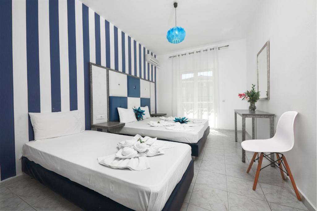 two beds in a room with blue and white stripes at Boulevard Studio's with side seaview in Laganas