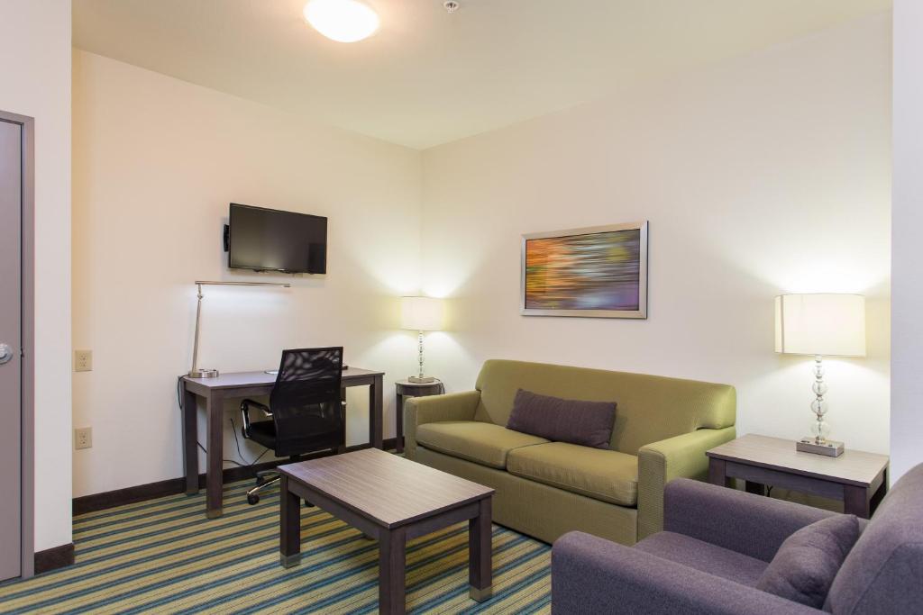 a living room with a couch and a desk at Holiday Inn Texarkana Arkansas Convention Center by IHG in Texarkana