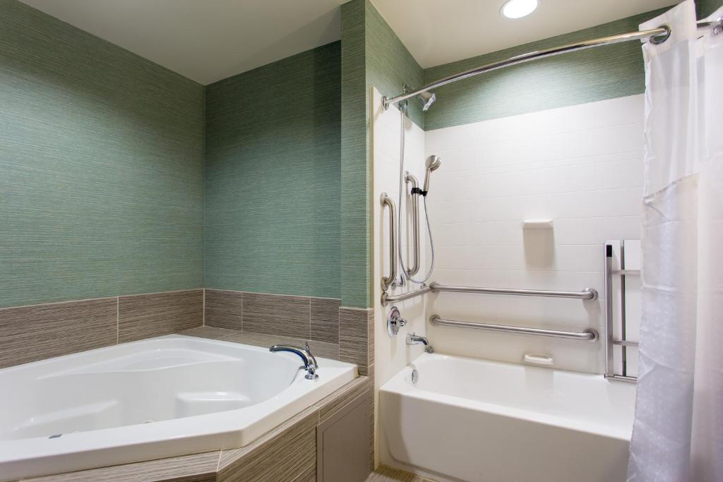 a bathroom with a tub and a sink at Holiday Inn Texarkana Arkansas Convention Center by IHG in Texarkana