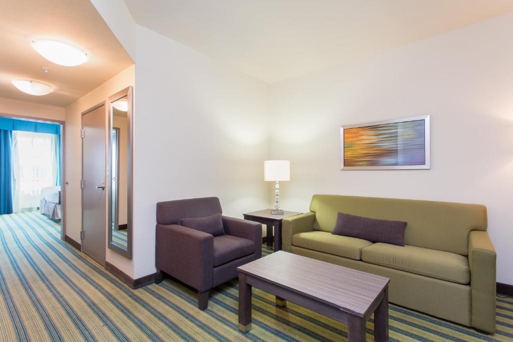 a living room with a couch and a chair and a table at Holiday Inn Texarkana Arkansas Convention Center by IHG in Texarkana