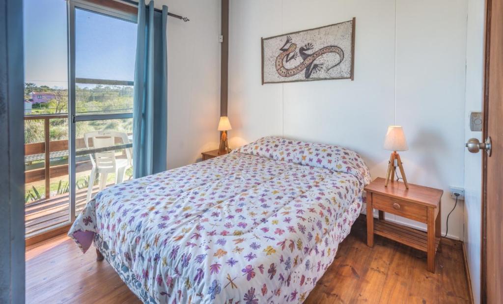 Schlafzimmer mit einem Bett und Blick auf einen Balkon in der Unterkunft Las yolandas in La Paloma