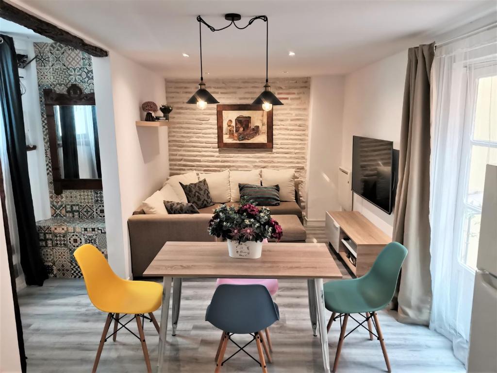 een woonkamer met een tafel en stoelen en een bank bij Casa Manuela Más que una Casa un Hogar in Toledo