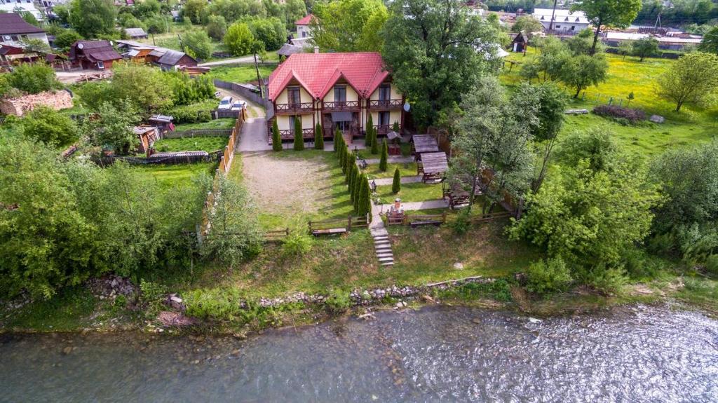 an aerial view of a house next to a river at На березі Черемошу in Verkhovyna