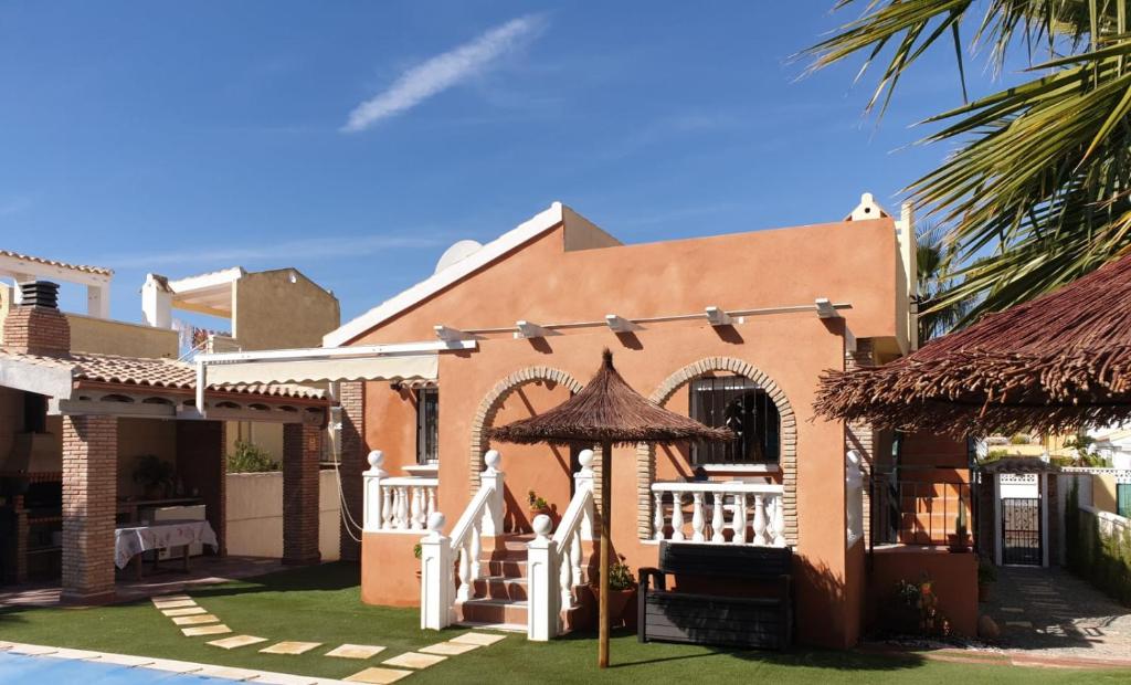 a house with an umbrella in the yard at Villa Preciosa in Camposol