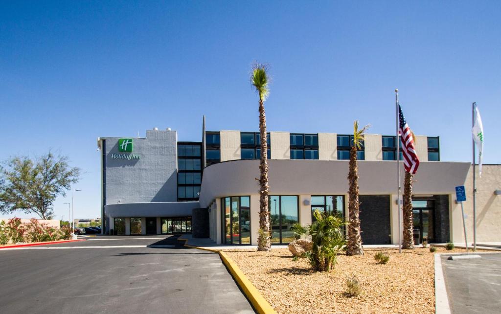 a building with palm trees in front of it at Holiday Inn Victorville, an IHG Hotel in Victorville