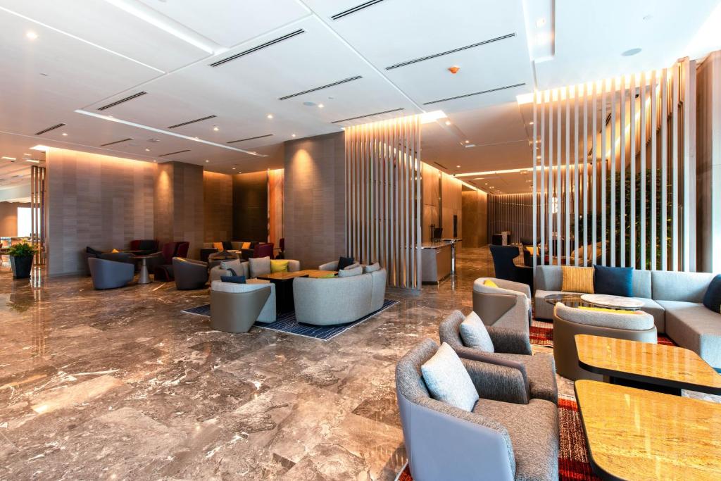 a lobby with couches and tables in a building at Holiday Inn Johor Bahru City Centre, an IHG Hotel in Johor Bahru