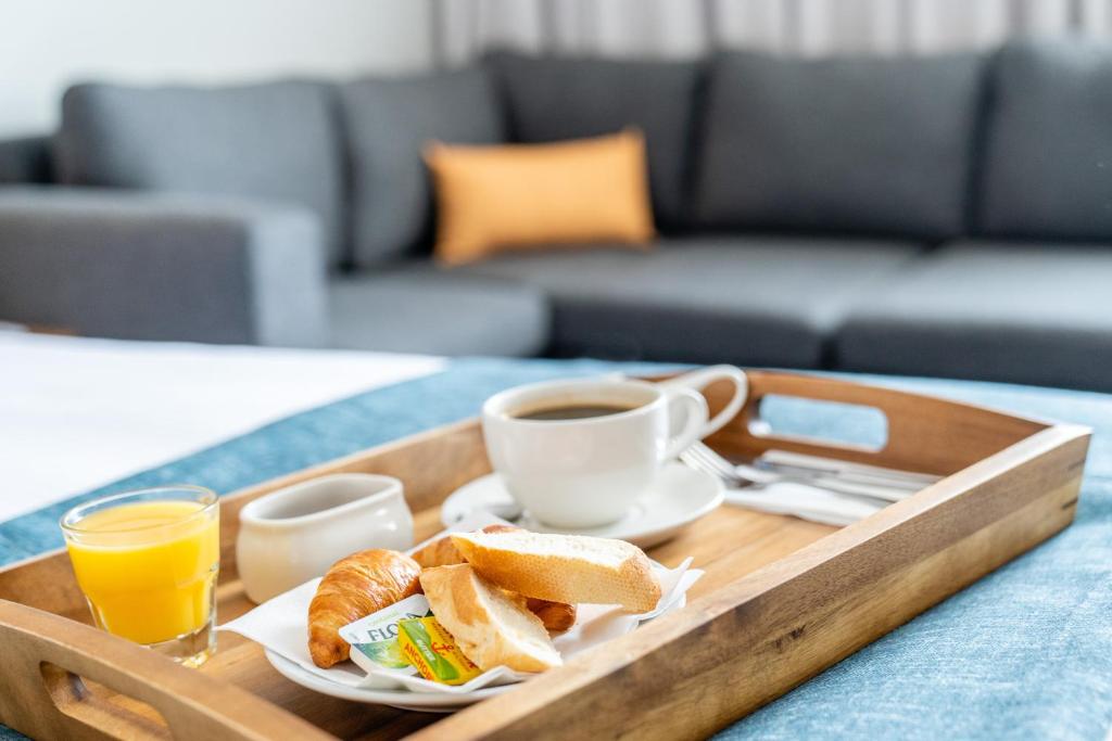 a tray with breakfast foods and a cup of coffee at Holiday Inn Bournemouth by IHG in Bournemouth