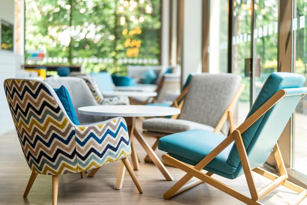 a group of chairs and tables in a room at Holiday Inn Bournemouth by IHG in Bournemouth