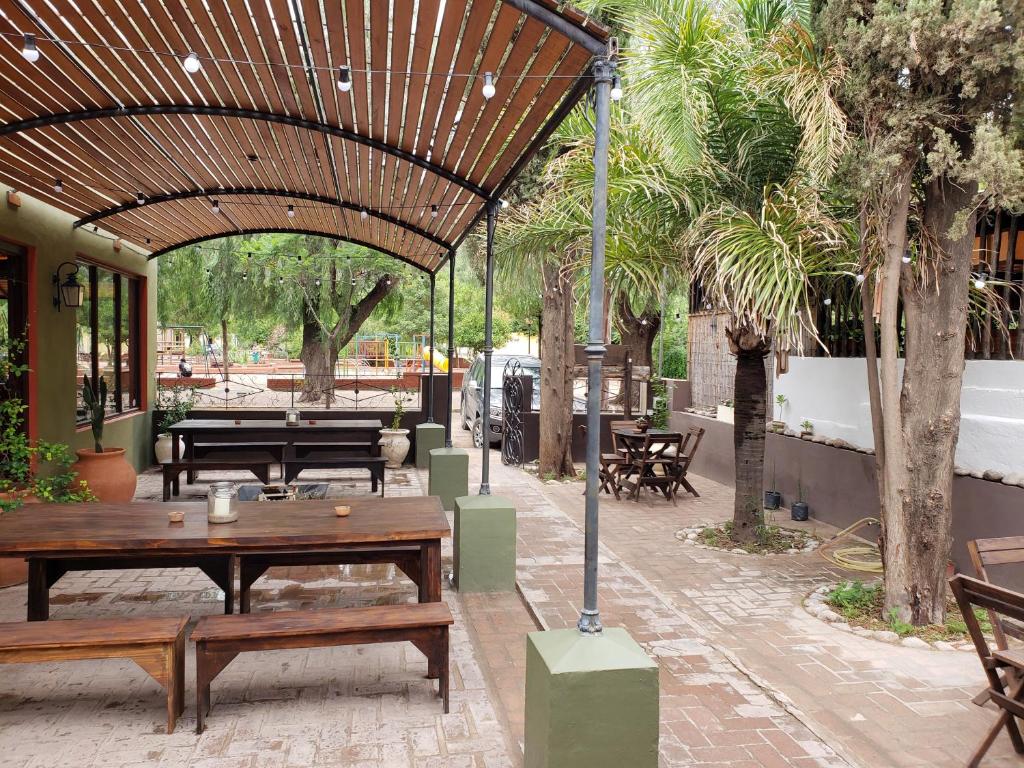 un patio al aire libre con mesa de madera y bancos en Posada Argimon en San Marcos Sierras