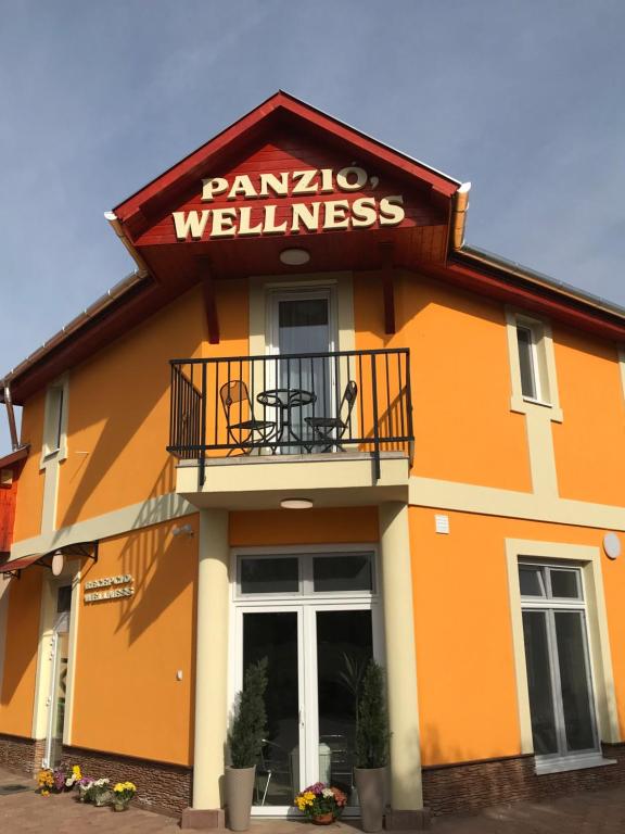 un edificio con un cartel que lee bienestar pandino en Tó- Party Panoráma Panzió & Wellness en Kiszombor