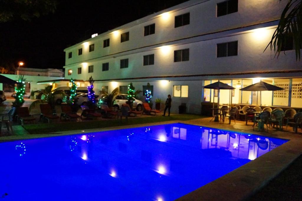 a swimming pool in front of a building at night at Hotel Las Dalias Inn in Mérida