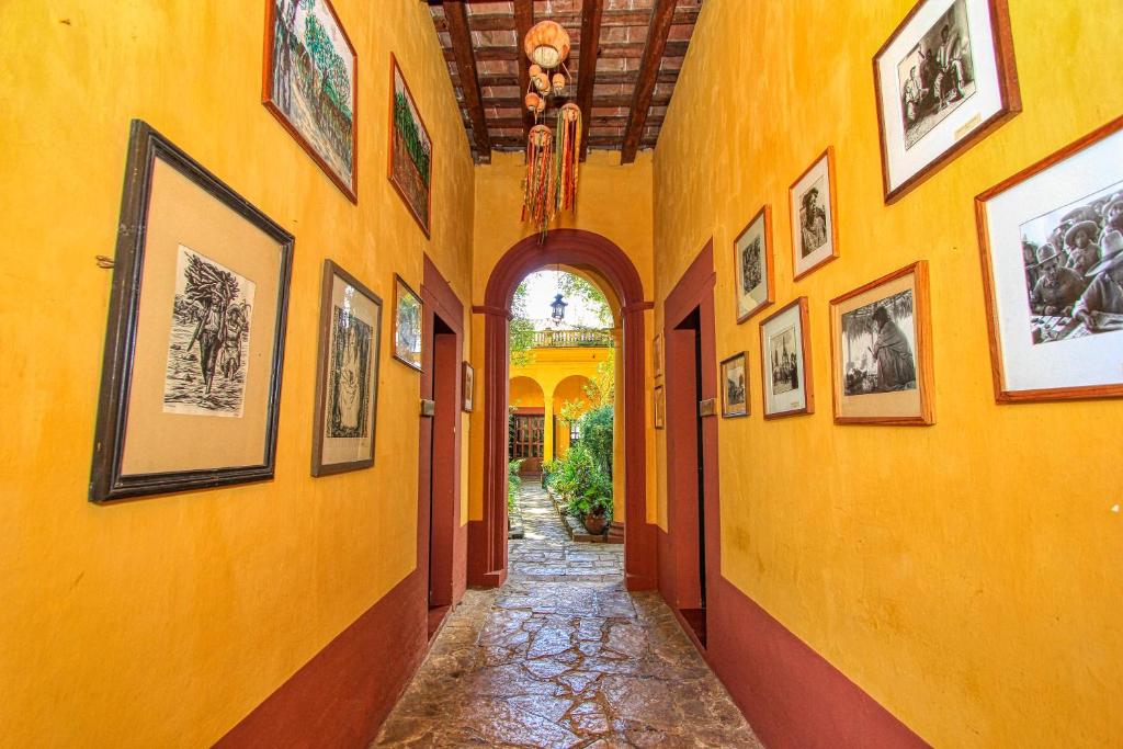 un corridoio con immagini sulle pareti di una casa di Hotel Na Bolom a San Cristóbal de Las Casas
