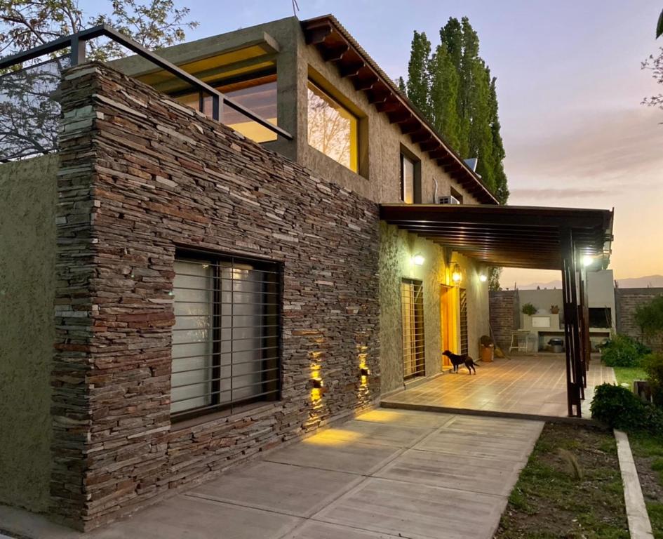 a brick house with a dog on a patio at El Lagar de Uco in La Consulta