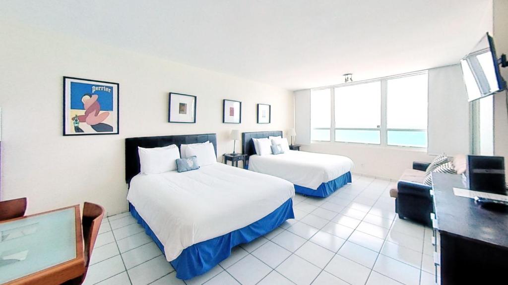 Habitación de hotel con 2 camas y sofá en Oceanfront studio with ocean view, easy beach access and free parking! en Miami Beach