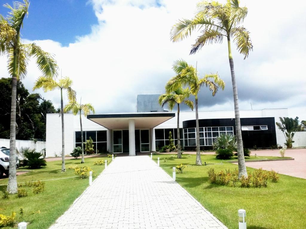 a building with palm trees in front of it at Hotel Abba Goiana PE in Goiana