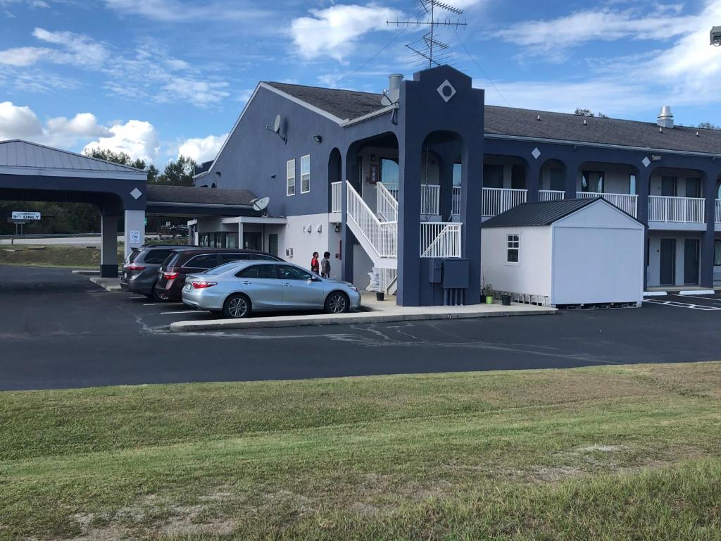 un gran edificio con coches estacionados en un estacionamiento en Budget Inn Timmonsville en Timmonsville