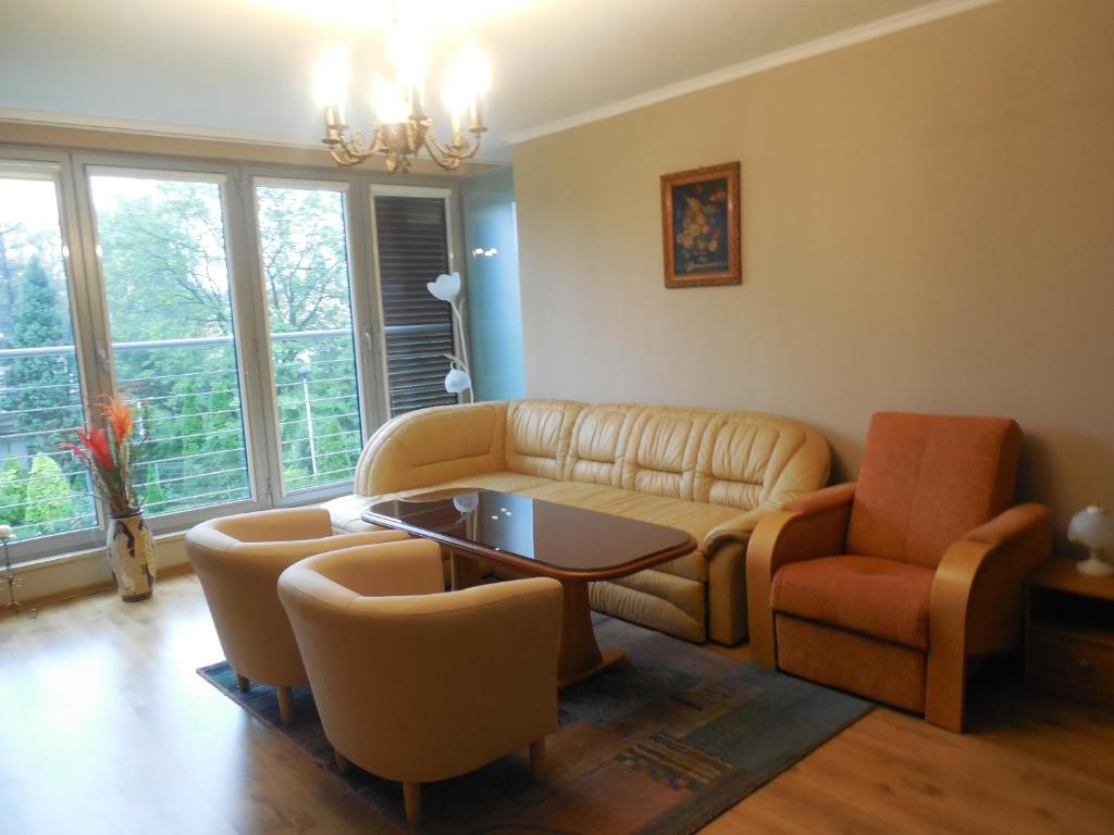 sala de estar con sofá, mesa y sillas en Apartament Familijny Beskidzki en Ustroń