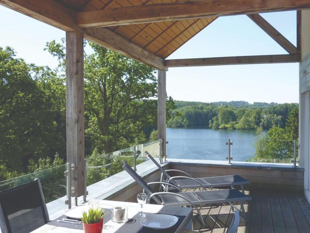 un porche con vistas al lago en Luxury apartment with sauna over a lake en Robertville