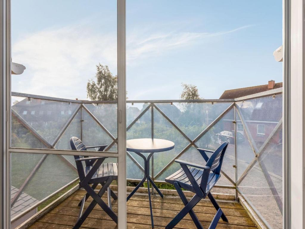 a balcony with two chairs and a table at Cozy Apartment in Insel Poel near Beach in Oertzenhof