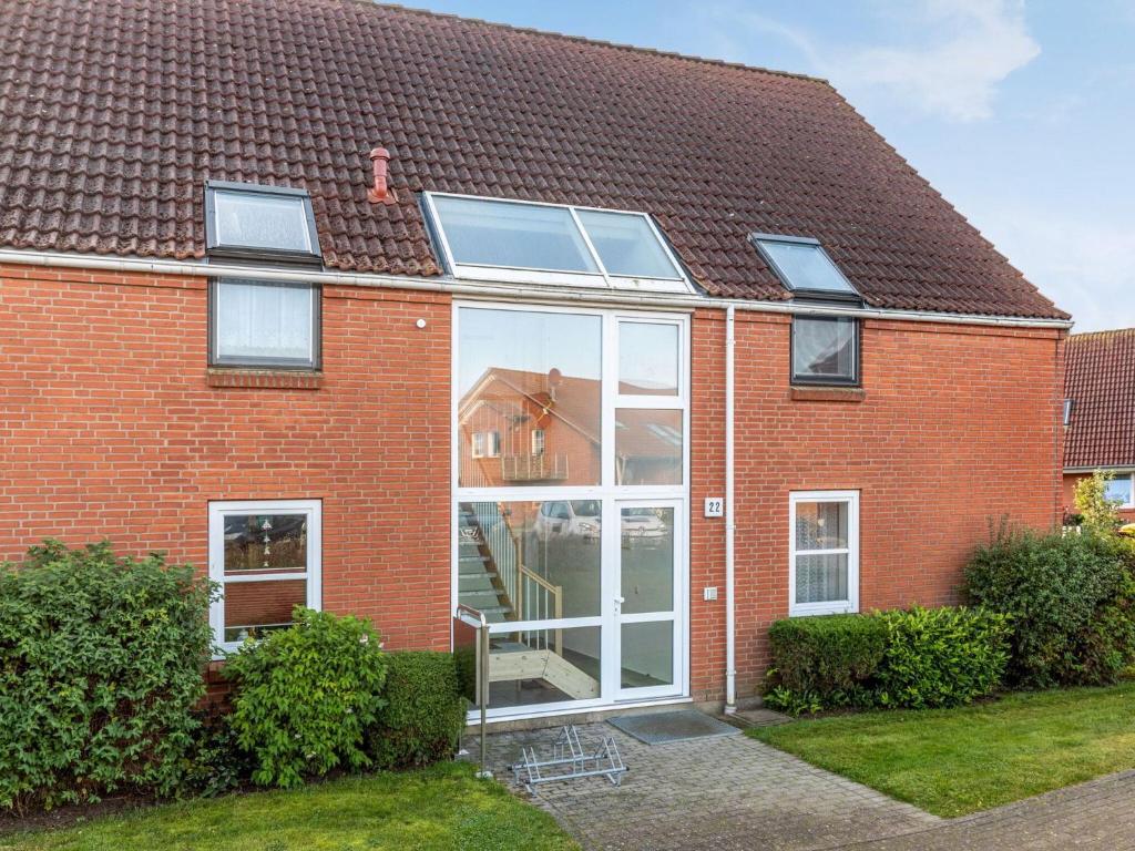a red brick house with large windows at Charmante Ferienwohnung in Kirchdorf Insel Poel in Oertzenhof