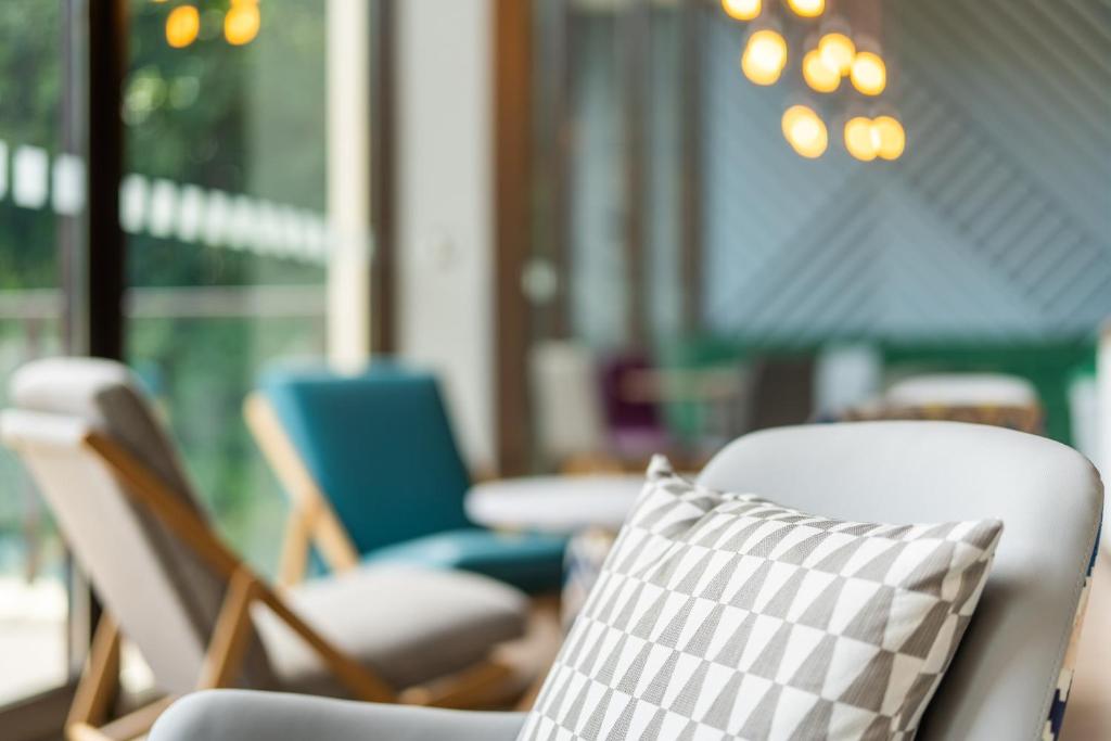 a grouping of chairs in a room with a pillow at Holiday Inn Bournemouth by IHG in Bournemouth