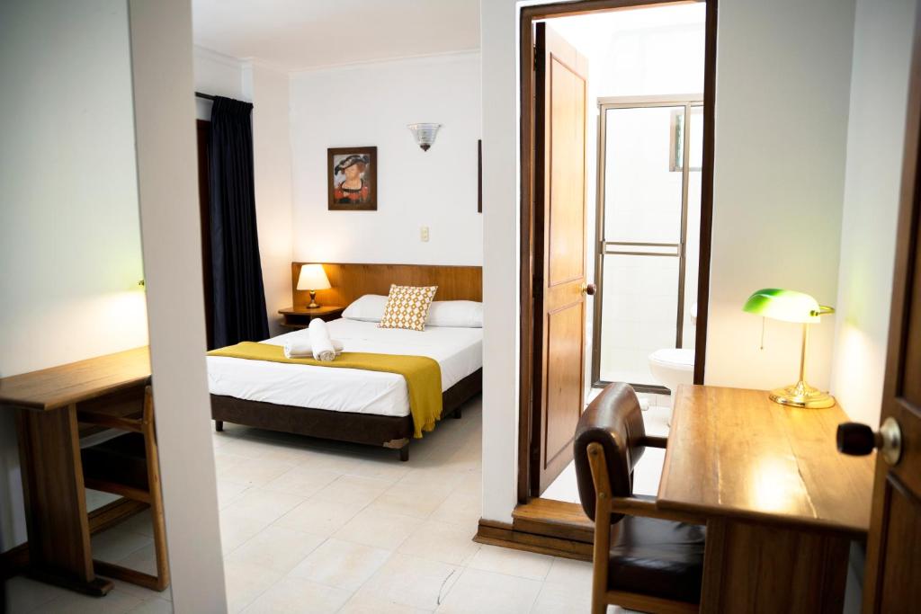 Habitación de hotel con cama y espejo en Casa Rosales, en Medellín
