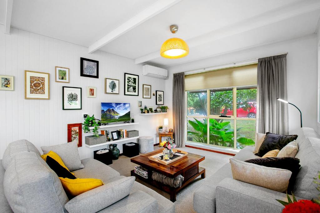 Sala de estar con 2 sofás y mesa en Cosy Cottage 2BR, NETFLIX, Private Garden Terrace en Korumburra