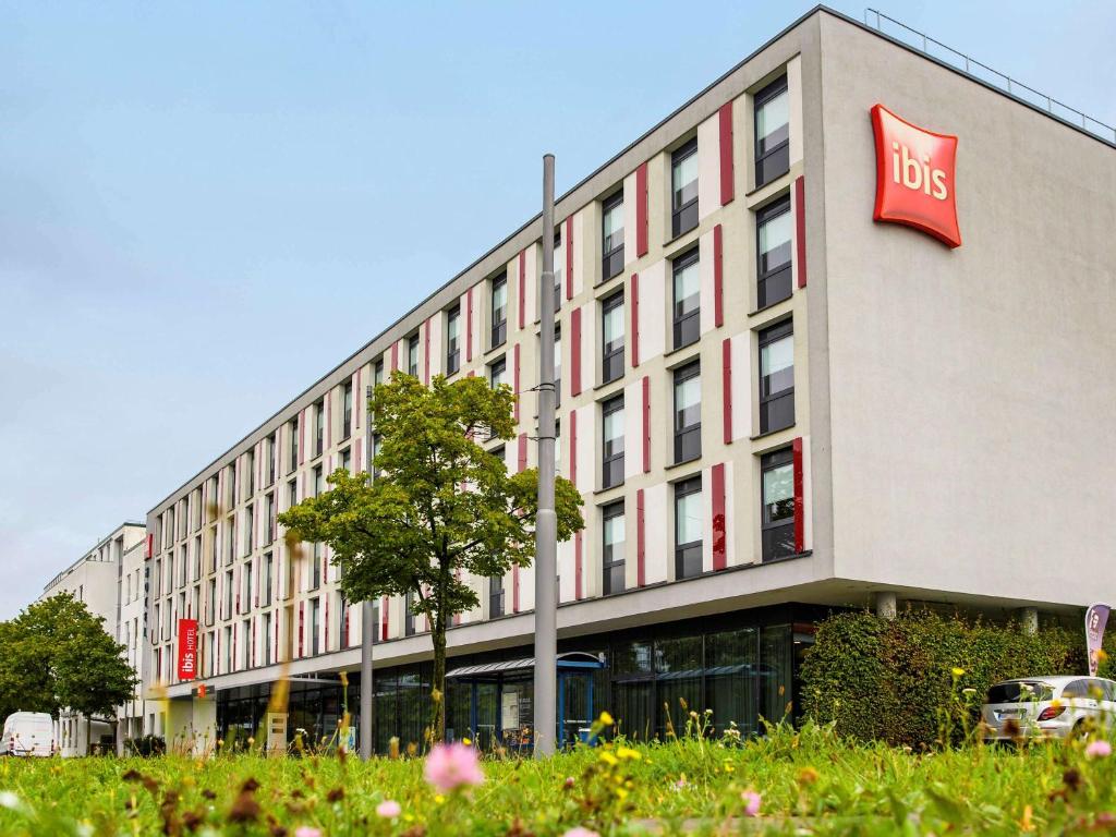 un grand bâtiment avec un panneau d'affichage dans l'établissement ibis Hotel Muenchen City West, à Munich