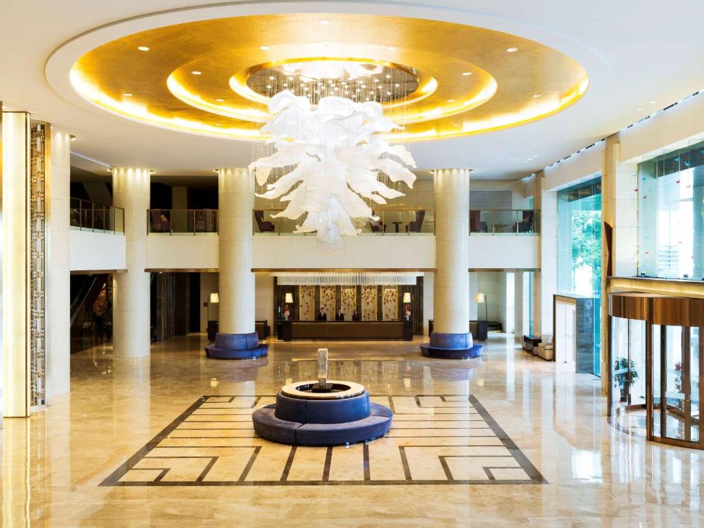 um lobby com um lustre no meio de um edifício em Pullman Changshu Leeman em Changshu