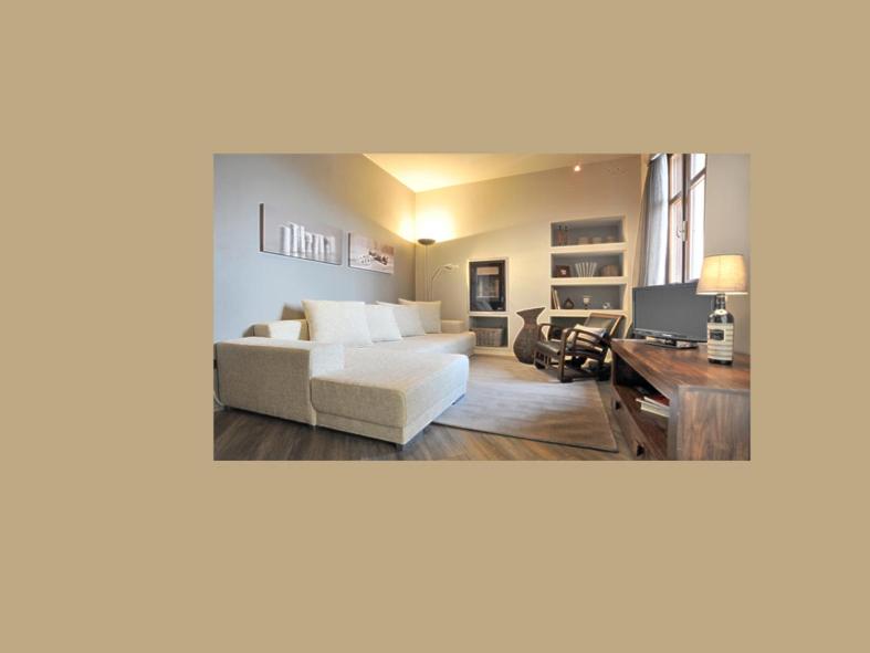 een woonkamer met een witte bank en een bureau bij Confortevole appartamento in centro a LA MORRA in La Morra
