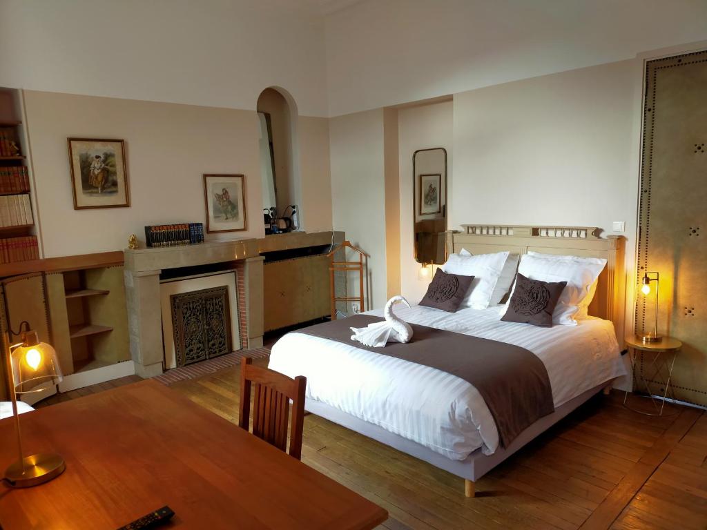 - une chambre avec un grand lit et une cheminée dans l'établissement La Maison Bleue de Roubaix, à Roubaix