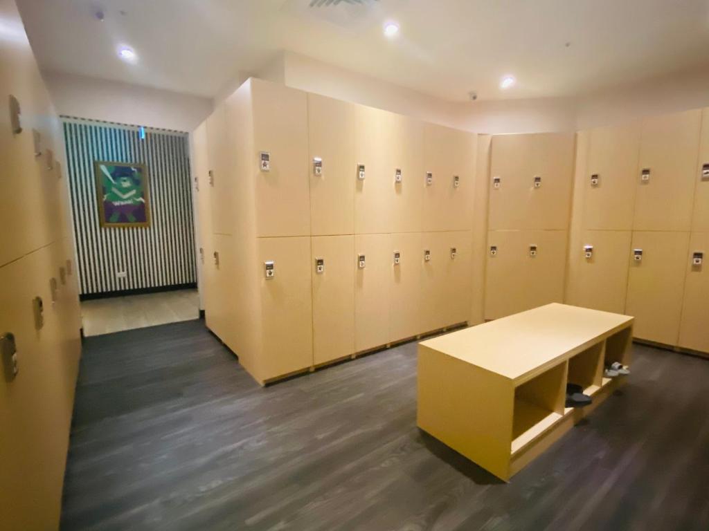 a locker room with a bench in the middle at Hey Bear Capsule Hotel in Taipei