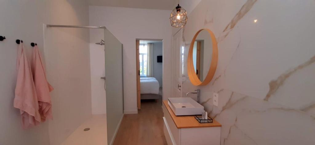 La salle de bains blanche est pourvue d'un lavabo et d'un miroir. dans l'établissement Haven 7, à Bruges