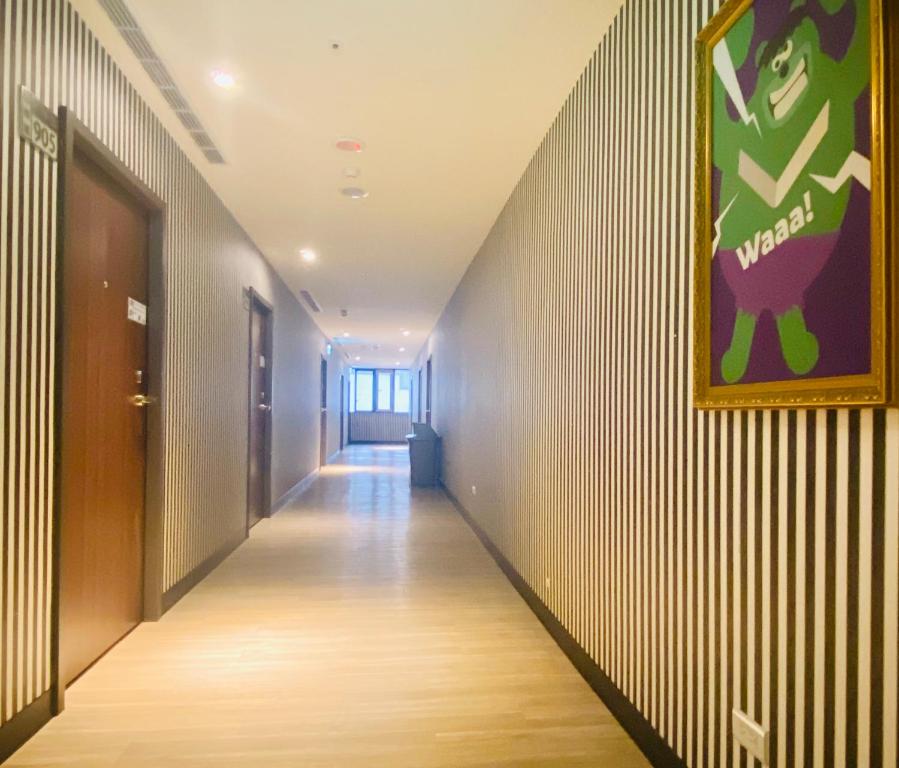 a corridor of an office building with a painting on the wall at Hey Bear Capsule Hotel in Taipei