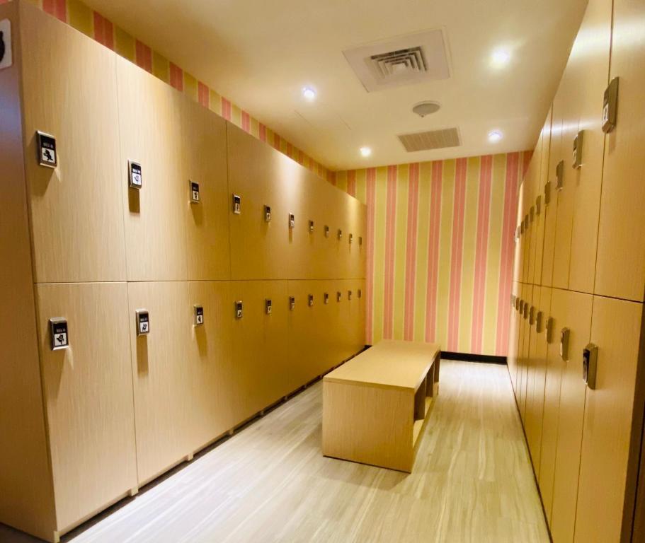 a locker room with a bench in the middle at Hey Bear Capsule Hotel in Taipei