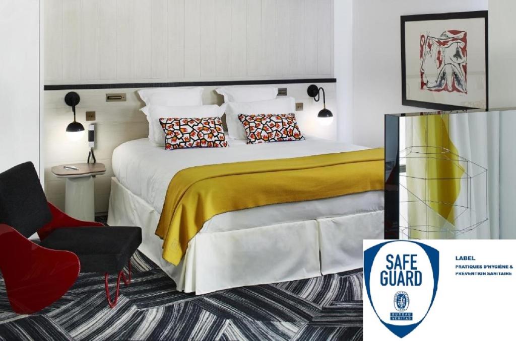 1 dormitorio con 1 cama con manta amarilla y silla en Hôtel du Ministère, en París