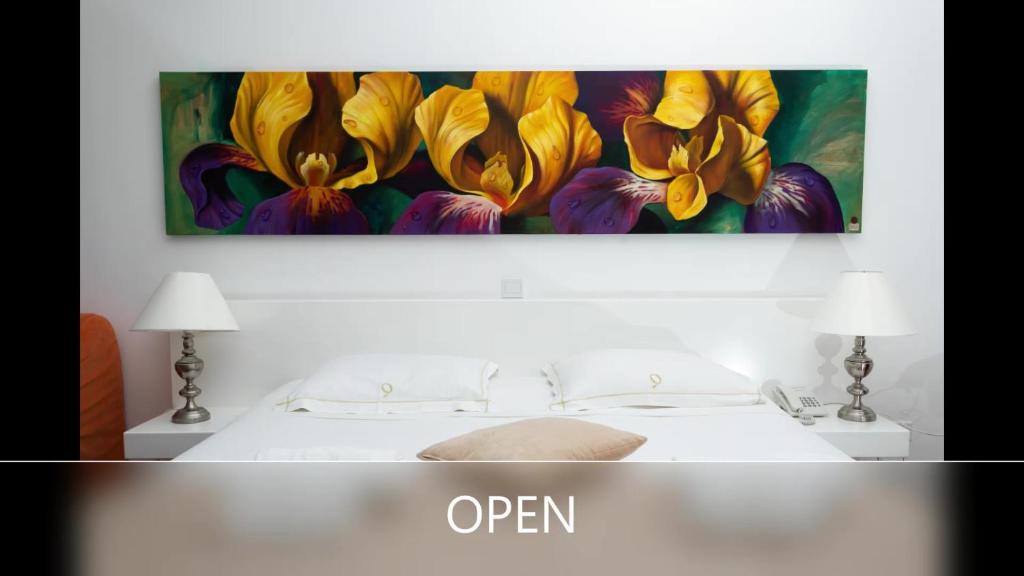 a painting of yellow flowers on a wall above a bed at Operetta House in Larnaka