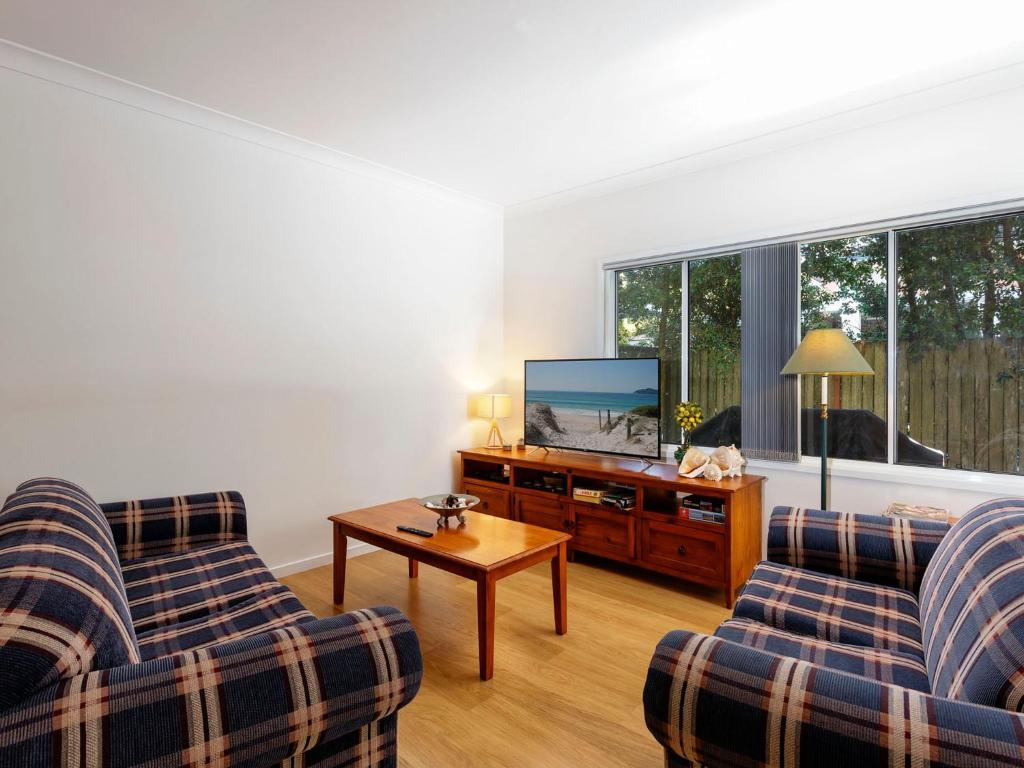 a living room with two couches and a flat screen tv at Three Bedroom Townhouse in Hawks Nest