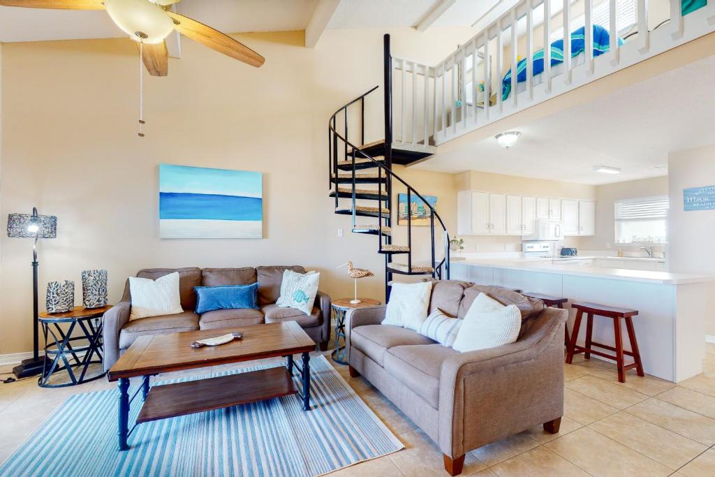 a living room with two couches and a spiral staircase at Lagoon Landing #302 in Gulf Shores