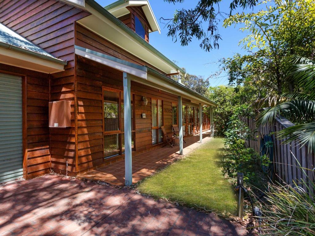 ein Haus mit einer Veranda und einem Hof in der Unterkunft Semaphore Beach House in Hawks Nest