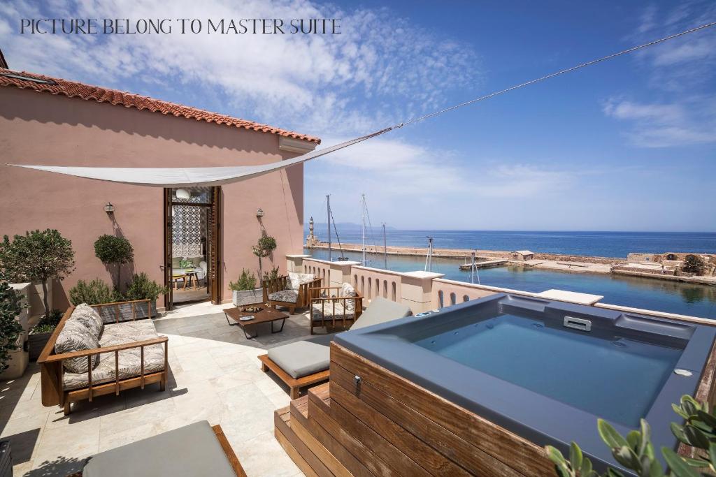 un patio con bañera de hidromasaje y vistas al océano en Ambassadors Residence Boutique Hotel, en La Canea