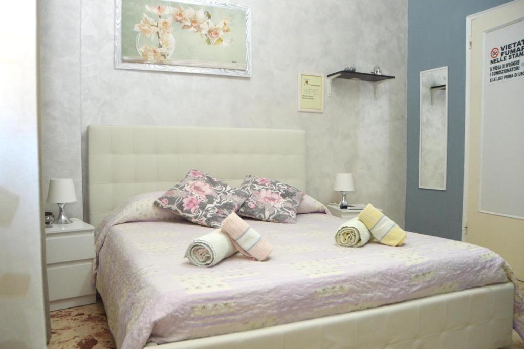 een slaapkamer met een bed met kussens erop bij B&B Tanese in Taranto