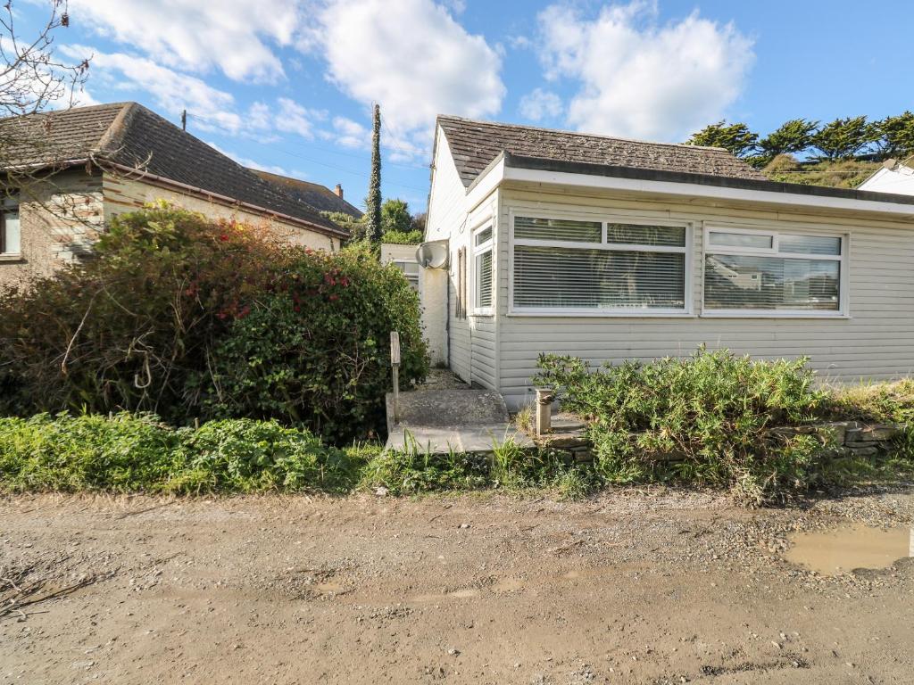 a white house with a driveway in front of it at Driftwood in Wadebridge