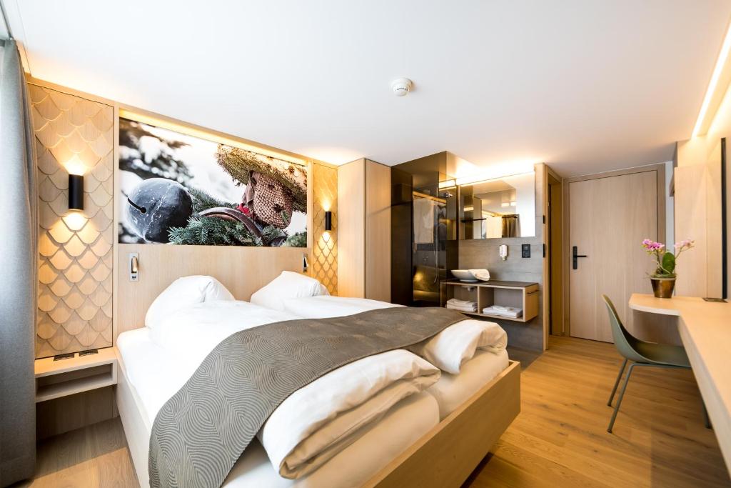 Urnäsch的住宿－Hotel- Restaurant Krone，一间卧室配有一张大床和一张书桌