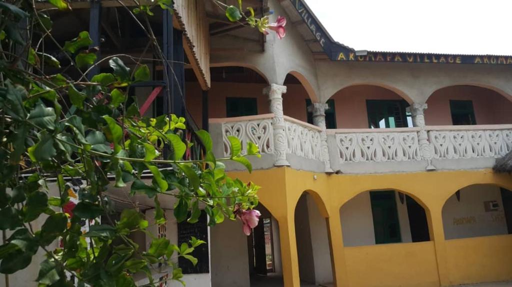 un edificio con un balcón en el lateral. en Akomapa Village, en Elmina